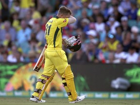 Australia's David Warner walks off after he was caught out by England during their one day international cricket match in Sydney, Sunday, Jan. 21, 2018.