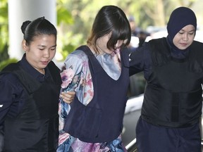 Vietnamese Doan Thi Huong, center, is escorted by police as she arrives for court hearing at Shah Alam court house in Shah Alam, Malaysia, Monday, Jan. 29, 2018. Doan and Siti Aisyah of Indonesia have pleaded not guilty to killing Kim Jong Nam on Feb. 13, 2017 at a crowded Kuala Lumpur airport terminal. They are accused of wiping VX on Kim's face in an assassination widely thought to have been orchestrated by North Korean leader Kim Jong Un.