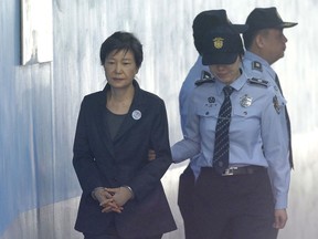 FILE - In this Oct. 10, 2017 file photo, Former South Korean President Park Geun-hye, left, arrives to attend a hearing on the extension of her detention at the Seoul Central District Court in Seoul, South Korea. An official says prosecutors have made additional bribery charges against the South Korea's jailed ex-president alleging she received official funds from her spy chiefs for personal purposes. A Seoul prosecutors' office official said Thursday, Jan. 4, 2018,  the new charges accuse Park of receiving a total of 3.5 billion won ($3.3 million) of official funds from three of her spy chiefs.