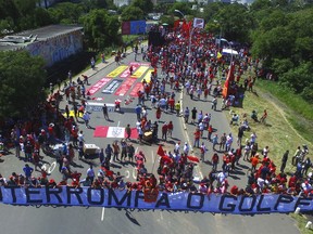 Supporters of ex-President Luiz Inacio Lula da Silva hold a banner that reads in Portuguese: "Stop the Coup" as they gather near the Federal Regional Court, where a three-member court is considering whether to uphold or throw out a corruption conviction against da Silva, in Porto Alegre, Brazil, Wednesday, Jan. 24, 2018. The decision could impact whether the former leader can run for president. The 72-year-old leads preference polls for October's race.