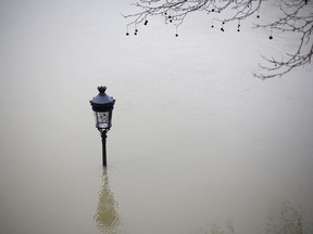 A flooded street lamp is pictured next to the river Seine in Paris, Saturday, Jan. 27, 2018. Floodwaters were nearing their peak in Paris on Saturday, with the rain-swollen Seine River engulfing scenic quays and threatening wine cellars and museum basements.