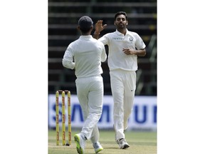 India's bowler Bhuvneshwar Kumar, right, celebrates with teammate after dismissing South Africa's batsman Dean Elgar, on the second day of the third cricket Test match between South Africa and India at the Wanderers Stadium in Johannesburg, South Africa, Thursday, Jan. 25, 2018.