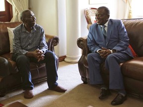 Zimbabwean President Emmerson Mnangagwa, right, talks to Morgan Tsvangirai, the main opposition leader in Zimbabwe, during a visit to his residence in Harare, Friday, Jan. 5, 2018. Mnangagwa said Tsvangirai is recovering well to treatment who is battling colon cancer.