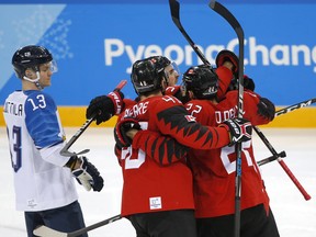 Canadian players celebrate Maxim Noreau's goal against Finland on Feb. 21.