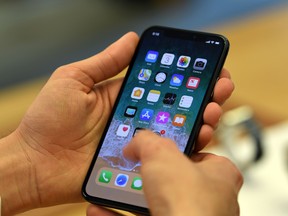 Customers set up an iPhone X at an Apple showroom in Sydney on November 3, 2017.