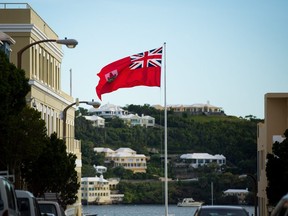 The flag of Bermuda flies as houses dot the hillside across Hamilton Harbour, November 8, 2017 in Hamilton, Bermuda.