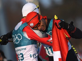 Pita Taufatofua of Tonga embraces Samir Azzimani of Morocco after crossing the finish line during of the men's 15-kilometre cross-country ski race on Feb. 16, 2018 in Pyeongchang.