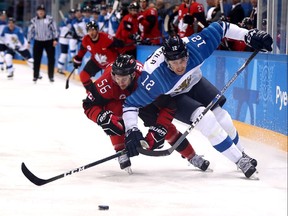 Canadian defenceman Maxim Noreau, left, works against Finland's Marko Anttila during the third period of their quarter-final on Feb. 21, 2018.