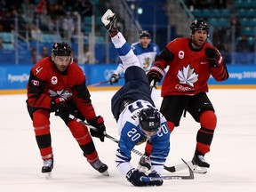 GANGNEUNG, SOUTH KOREA - FEBRUARY 21:  Eeli Tolvanen #20 of Finland is upended by Chris Lee #4 and Derek Roy #9 of Canada in the third period during the Men's Play-offs Quarterfinals on day twelve of the PyeongChang 2018 Winter Olympic Games at Gangneung Hockey Centre on February 21, 2018 in Gangneung, South Korea.