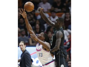 Milwaukee Bucks center Thon Maker, right, bats the ball away from Miami Heat center Bam Adebayo (13) during the first half of an NBA basketball game Friday, Feb. 9, 2018, in Miami.