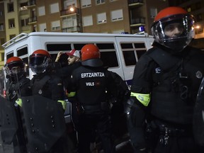 Basque riot police controls a follower of FC Spartak Moskva before the match during the Europa League - round of 32, 2nd leg, between Athletic Bilbao and FC Spartak Moskva, at San Mames stadium, in Bilbao, northern Spain, Thursday, Feb.22, 2018.