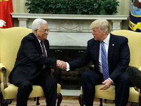 U.S. President Donald Trump shakes hands with Palestinian leader Mahmoud Abbas during a meeting in the Oval Office on May 3, 2017.