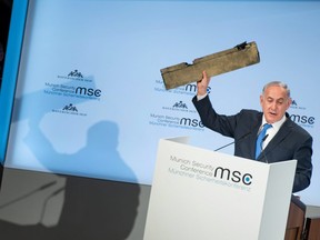 Israeli Prime Minister Benjamin Netanyahu holds up what he claimed was a piece of an Iranian drone shot down in Israeli airspace, as he gives a speech during the Munich Security Conference on February 18, 2018 in Munich, southern Germany.