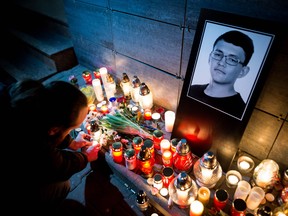 A man lights a candle in front of the Aktuality newsroom, the employer of the murdered investigative journalist Jan Kuciak, on February 26, 2018 in Bratislava.