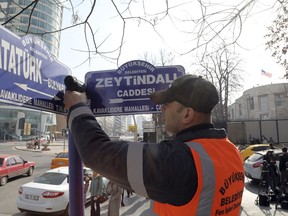 An Ankara municipality worker fixes the new street sign, "Olive Branch Street" in Turkish, named after Turkey's military operation to drive out the Syrian Kurdish militia of an enclave in northwest Syria, in Ankara, Turkey, Monday, Feb. 19, 2018. Municipality workers on Monday took down the street sign for Nevzat Tandogan Street where the U.S. Embassy is located and replaced it with one that reads "Olive Branch Street."