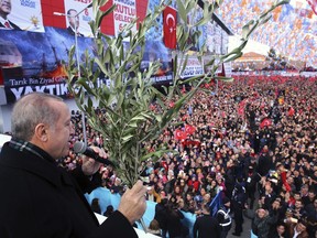 Turkey's President and leader of ruling Justice and Development Party Recep Tayyip Erdogan holds olive branches as he addresses the party members in Eskisehir, Turkey, Saturday, Feb. 17, 2018. "Olive Branch" is the codename of Turkey's military operation against the US-backed Syrian Kurdish militia in northwestern Syria.