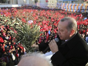 Turkey's President Recep Tayyip Erdogan holds olive branches as he addresses his party members in Batman, Turkey, Saturday, Feb. 3, 2018. The Turkish military says two of its soldiers have been killed in Syria and a third was killed on the Turkish side of the border in an attack by Syrian Kurdish militiamen.