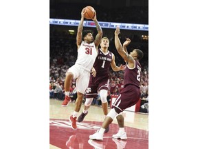 Arkansas guard Anton Beard drives to the hoop past Texas A&M defenders DJ Hogg (1) and TJ Starks (2) during the first half of an NCAA college basketball game Saturday, Feb. 17, 2018, in Fayetteville, Ark.