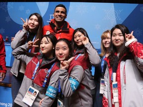 Cross-country skier Pita Taufatofua of Tonga poses with volunteers at a press conference in the Main Press Centre during the 2018 Winter Olympics on Feb. 14, 2018.