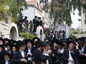 Ultra orthodox Jewish men gather during the funeral of Rabbi Shmuel Auerbach in Jerusalem, Sunday, Feb. 25, 2018. Tens of thousands of ultra-Orthodox Jews are attending the funeral of the influential rabbi who died on Saturday in Jerusalem.