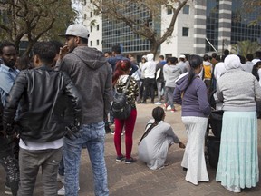 In this Wednesday, Feb. 7, 2018 photo, African migrants gather during a protest in front of the Rwanda embassy in Herzeliya, Israel. Tens of thousands of African asylum seekers, nearly all from dictatorial Eritrea and war-torn Sudan, fear their stay in Israel is coming to an abrupt end. The Israeli government has given them until April 1 to leave the country for an unnamed African destination -- known to be Rwanda -- in exchange for $3,500 and a plane ticket, or they will be incarcerated indefinitely.
