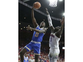 UCLA guard Kris Wilkes (13) drives to the basket past the defense of Arizona's Rawle Alkins during the first half of an NCAA college basketball game, Thursday, Feb. 8, 2018, in Tucson, Ariz.