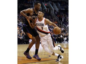 Portland Trail Blazers guard CJ McCollum (3) drives on Phoenix Suns forward TJ Warren during the first half of an NBA basketball game Saturday, Feb. 24, 2018, in Phoenix.