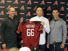 Arizona Diamondbacks manager Torey Lovullo, left, and general manager Mike Hazen, right, flank pitcher Yoshihisa Hirano, of Japan, during an introductory press conference, Monday, Feb. 12, 2018, in Scottsdale, Ariz.