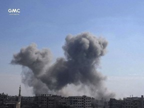 In this photo released on Wednesday Feb. 21, 2018, provided by the Syrian anti-government activist group Ghouta Media Center, which has been authenticated based on its contents and other AP reporting, shows smoke rising after Syrian government airstrikes hit Ghouta, suburb of Damascus, Syria. New airstrikes and shelling on the besieged, rebel-held suburbs of the Syrian capital killed at least 10 people on Wednesday, a rescue organization and a monitoring group said.