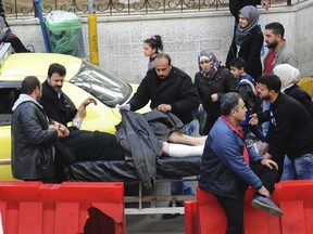 This photo released on Tuesday, Feb. 20, 2018 by the Syrian official news agency SANA, shows Syrians carrying a man who was injured by the shelling of the Syrian opposition fighters, in Damascus, Syria. As the Syrian government steps up its attacks on the opposition-held suburbs of Damascus, rebels in outlying towns are retaliating by sending volleys of mortar shells into the capital, killing more than 25 civilians in the past two weeks and spreading fear among its four residents.