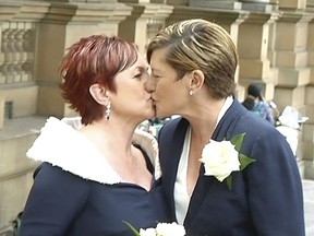 In this image made from Australia Broadcasting Corporation video, Christine Forster, right, sister of former Australian prime minister Tony Abbott, kisses her partner Virginia Edwards, Friday, Feb. 2, 2018, in Sydney, Australia. Tony Abbott joined his sister Christine when she married her partner Virginia Edwards in a civil ceremony overlooking the Sydney Opera House on Friday. While Abbott vehemently opposes gay marriage, he has long said he would attend his sister's wedding if the same-sex marriage ban was ever lifted.