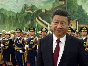 FILE - In this Tuesday, Jan. 9, 2018, file photo, Chinese President Xi Jinping reviews a Chinese honor guard during a welcome ceremony for a visiting dignitary at the Great Hall of the People in Beijing. In a rare public expression of dissent in China, a well-known political commentator and a prominent businesswoman penned open letters urging lawmakers to reject a plan that would allow President Xi Jinping to rule indefinitely.