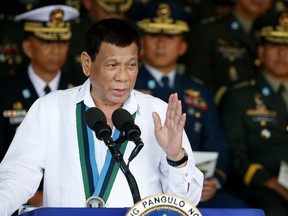 FILE - In this Wednesday, Dec. 20, 2017, file photo, Philippine President Rodrigo Duterte addresses the troops during the 82nd anniversary celebration of the Armed Forces of the Philippines in suburban Quezon city northeast of Manila, Philippines. Human rights groups say the Philippine president's recent remarks about troops shooting female communist rebels in the genitals to render them "useless" can encourage sexual violence and war crimes.