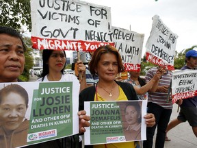 FILE - In this Wednesday, Feb. 21, 2018, file photo, protesters picket the Senate at the start of the probe in the death of an overseas worker in Kuwait, Pasay city south of Manila, Philippines. The Philippine president says a ban on the deployment of workers to Kuwait, where a Filipina was found dead in a freezer, will continue and could be expanded to other countries where Filipino workers "suffer brutal treatment and human degradation."