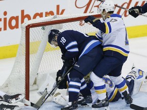 Winnieg Jets' Bryan Little tries to wreak havoc on St. Louis Blues goaltender Jake Allen during NHL action Friday in Winnipeg. Defenceman Jaden Schwartz comes to the aid of his goaltender. The Blues were 5-2 winners.