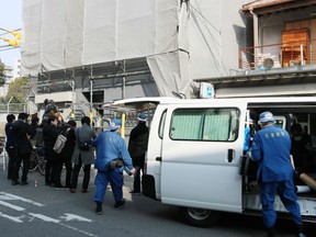 Hyogo prefectural police (R) are pictured at the scene as they investigate an apartment (L) where a decapitated head was found in Osaka on February 25, 2018.The woman’s head was found Saturday in a suitcase at a short-term lodging facility, or minpaku, in the Nishinari ward of the city of Osaka, investigators told the local news media.