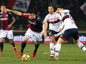 Bologna's Blerim Dzemaili, left, is challenged by Genoa's Andrea Bertolacci during the Serie A soccer match between Bologna and Genoa at the Renato Dall'Ara Stadium in Bologna, Italy, Saturday, Feb. 24, 2018.