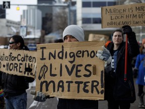 People gather with signs during a rally in response to Gerald Stanley's acquittal in the shooting death of Colten Boushie in Edmonton, Alta., on Saturday, February 10, 2018.