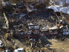 FILE - In this Feb. 20, 2003, aerial file photo, firefighters work amid the charred ruins of The Station nightclub, where 100 people died in a late night fire in West Warwick, R.I., started when pyrotechnics for the rock band Great White set fire to flammable foam installed as soundproofing. The site of the fire is now a memorial park where some survivors and victims' relatives will gather 15 years later on Tuesday, Feb. 20, 2018, to discuss a new federal tax incentive for sprinkler installation.