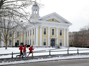 FILE - In this Jan. 14, 2016 file photo, runners make their way along a sidewalk on the campus of Wheaton College in Norton, Mass. Wheaton is getting a $10 million donation in 2018 from the Diana Davis Spencer Foundation, a conservative backer whose namesake is a Wheaton alumna. The gift will create an endowed professorship on social entrepreneurship and new space for existing programs on the topic.