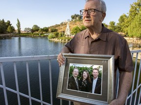 FILE - In this Friday, June 23, 2017, file photo, Frank Kerrigan holds onto a photograph of his three children John, Carole, and Frank, near Wildomar, Calif. A family who thought they had buried their loved one only to found out he was alive 11 days after his funeral is now suing the California county responsible for what they say started as a mix-up but became a cover-up.