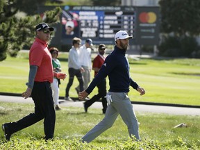 Ted Potter Jr., left, and Dustin Johnson, right, walks down the third fairway of the Pebble Beach Golf Links during the final round of the AT&T Pebble Beach National Pro-Am golf tournament Sunday, Feb. 11, 2018, in Pebble Beach, Calif.