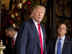 FILE - In this Dec. 21, 2016 file photo, President-elect Donald Trump, center, accompanied by Trump Chief of Staff Reince Priebus, right, and retired Gen. Michael Flynn, a senior adviser to Trump, left, speaks to members of the media at Mar-a-Lago, in Palm Beach, Fla. President Trump's first chief of staff says all those reports about chaos in the early days of the Trump White House were true - and then some. Priebus' recollections come in author Chris Whipple's book "The Gatekeepers" to be published in March 2018.
