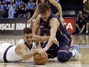 San Diego forward Isaiah Pineiro (0), left, battle St. Mary's guard Tanner Krebs (00) for the ball during the first half of an NCAA college basketball game Saturday, Feb. 3, 2018, in San Diego.