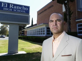 FILE - In this July 21, 2010, file photo, teacher Gregory Salcido poses in front of El Rancho High School in Pico Rivera, Calif. A Los Angeles-area city council will consider a resolution Tuesday, Feb. 13, 2018, asking for the resignation of councilman Salcido, who bashed U.S. military service members while teaching to a high school class.