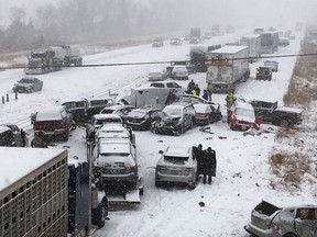In this photo provided by KCCI-TV, emergency personnel tend to vehicles on Interstate 35 in Ames, Iowa, after dozens of vehicles collided on the snow-covered freeway Monday, Feb. 5, 2018, forcing the closure of the southbound lanes. (KCCI-TV via AP)