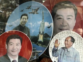 Porcelain plates featuring portraits of former Chinese leader Mao Zedong, bottom right, and Chinese President Xi Jinping stand on display at a store window in Beijing, China, on Monday, Feb. 26, 2018. China's Communist Party is set to repeal presidential term limits in a move that would allow Xi to rule beyond 2023, completing the country's departure from a political system based on collective leadership.