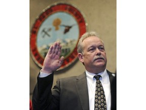 FILE - In this Dec. 31, 2014 file photo, Bill Elder is sworn in as interim sheriff of El Paso County by Judge Gilbert Martinez at Centennial Hall in Colorado Springs, Colo. The Colorado American Civil Liberties Union on Tuesday, Feb. 27, 2018, filed a lawsuit contending a Sheriff's department is improperly holding people in the country illegally on behalf of federal authorities in what is believed to be the first legal challenge to a Trump administration effort to work around court rulings limiting how it can work with local jails to enforce immigration laws. The complaint in Colorado District Court alleges that El Paso County Sheriff Bill Elder "holds prisoners in custody for days, weeks and even months after state law requires their release."