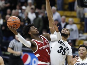 Stanford guard Daejon Davis, left, drives the lane to the basket as Colorado forward Dallas Walton defends in the first half of an NCAA college basketball game Sunday, Feb. 11, 2018, in Boulder, Colo.