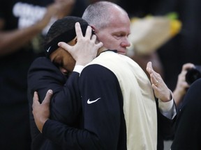 Colorado guard George King, left, hugs head coach Tad Boyle during a ceremony to mark King's final home game for the team as it hosts UCLA in the first half of an NCAA college basketball game Sunday, Feb. 25, 2018, in Boulder, Colo.